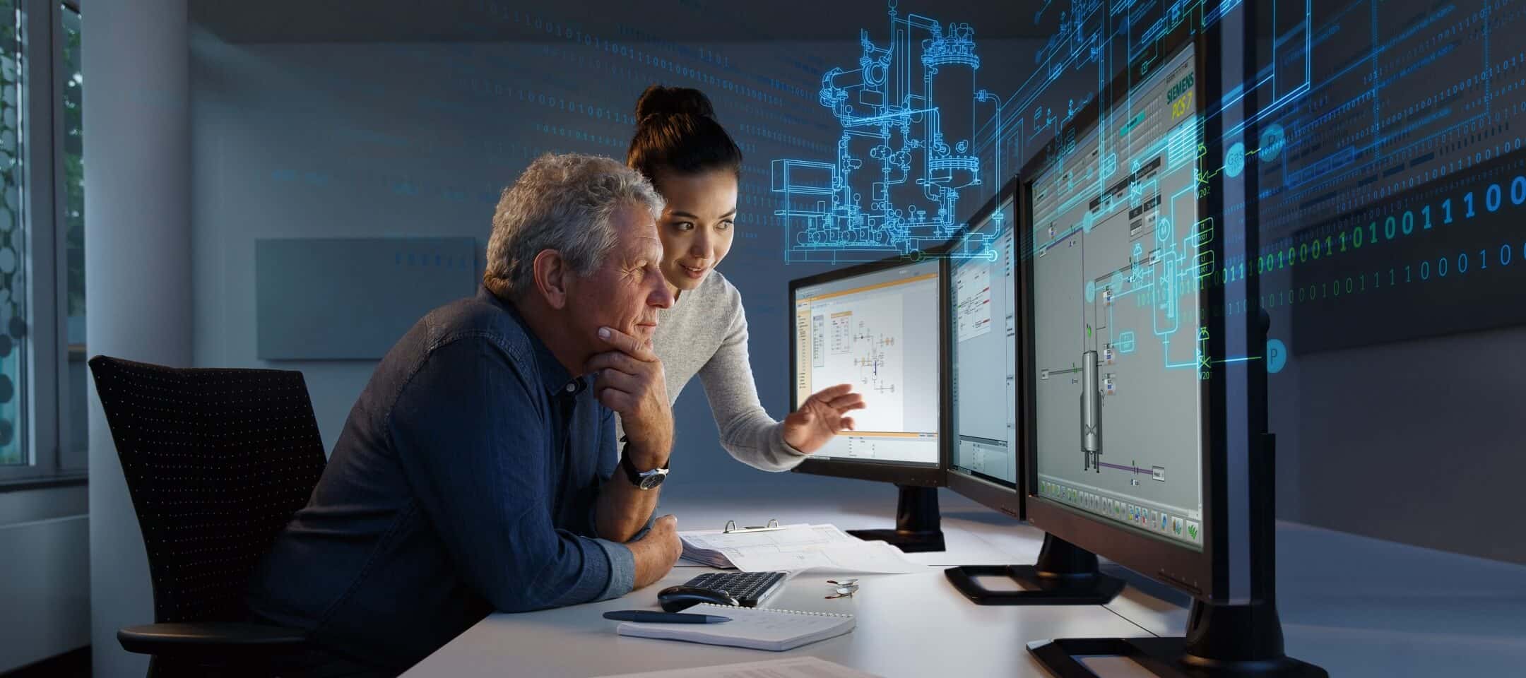 Photo d'un homme et d'une femme dans un bureau en train d'analyser des informations sur des ordinateurs